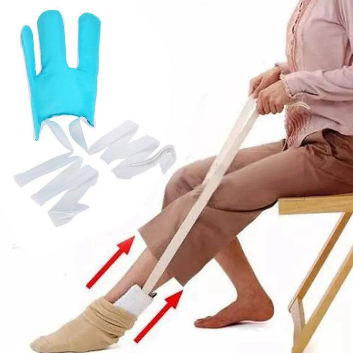 Sitting on a chair, a person uses the Sock Aid Device No Bending Sock Helper to easily apply socks. This blue tool, with long white straps, securely holds the sock as the foot slides in, ensuring a smooth fit.