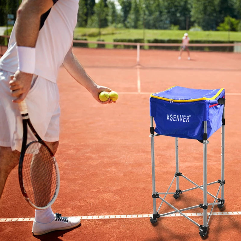 A tennis player in white attire stands on a clay court, holding two tennis balls and a racket. Next to them is the "ASENVER" Tennis Training Device Cart, showcasing its durable stainless steel frame and movable basket storage basin. In the background, another player contributes to the scene's dynamic energy.