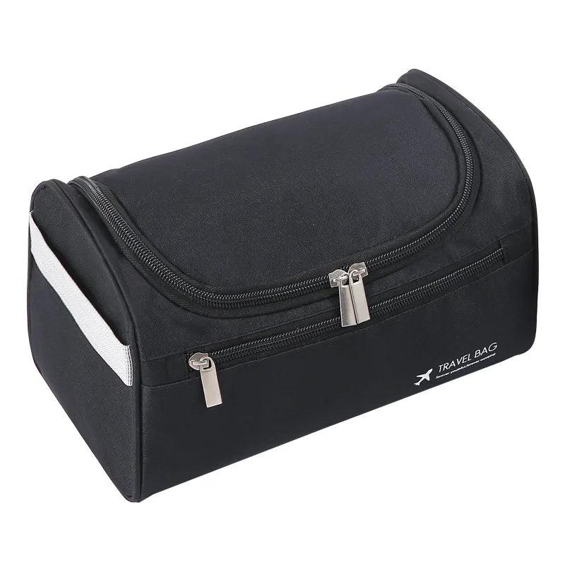 A stylish black Men's Travel Toiletry Bag features a curved, zippered opening with two silver zippers. The words "Travel Bag" and an airplane icon are printed in white on the side of this waterproof pouch, which also includes a convenient white strap for easy carrying.