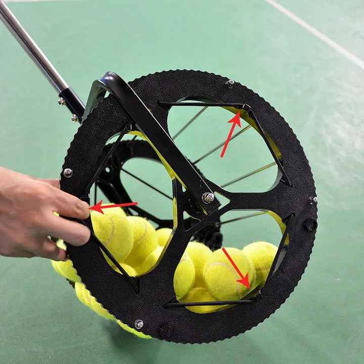 The Tennis Trainer Ball Picker High-Capacity Ball Retriever Portable Storage Holder efficiently gathers yellow tennis balls from a green surface using its large, spoked wheel. Designed for hand operation, it includes red arrows highlighting features or instructions, making it an essential tool for any tennis trainer.