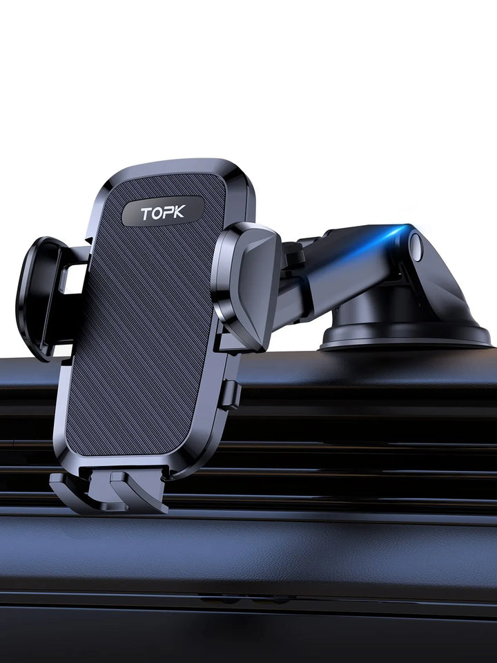 A black Car Phone Holder Adjustable Mount for Dashboard, featuring Gravity Expansion Technology and a suction cup base, is attached to a dashboard. It includes adjustable grips, a sleek modern design, and a 360° Ball Joint for optimal viewing angles, with the brand name "TOPK" displayed on the holder.