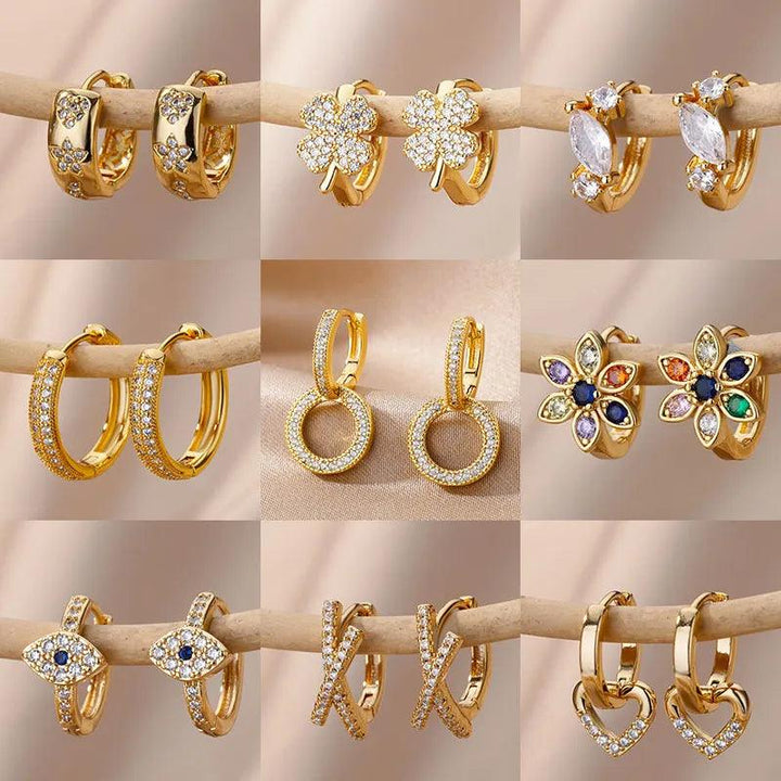 A set of nine pairs of gold earrings is showcased in a grid layout, featuring various designs such as floral motifs, geometric shapes, and gemstone accents like the Zircon Round Hoop Earrings. Each pair is intricately detailed with glossy gold embellishments against a neutral background, making them an elegant gift option.