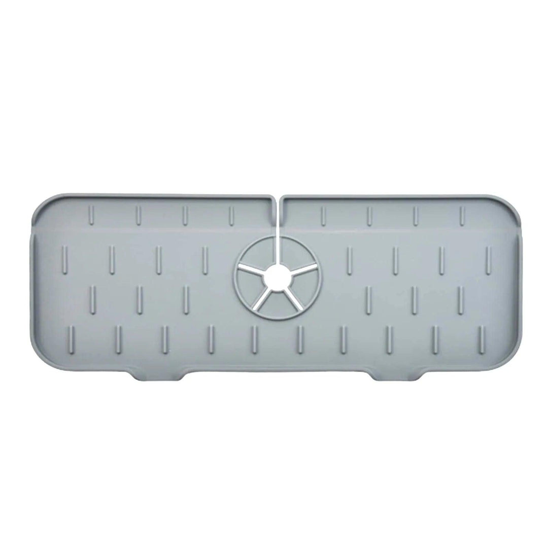 The Faucet Guard Kitchen Mat for Kitchen Sinks is a gray rectangular silicone mat featuring a circular hole in the center and raised vertical lines across its surface. Its edges are slightly curved, designed to be an eco-friendly protective sink liner.