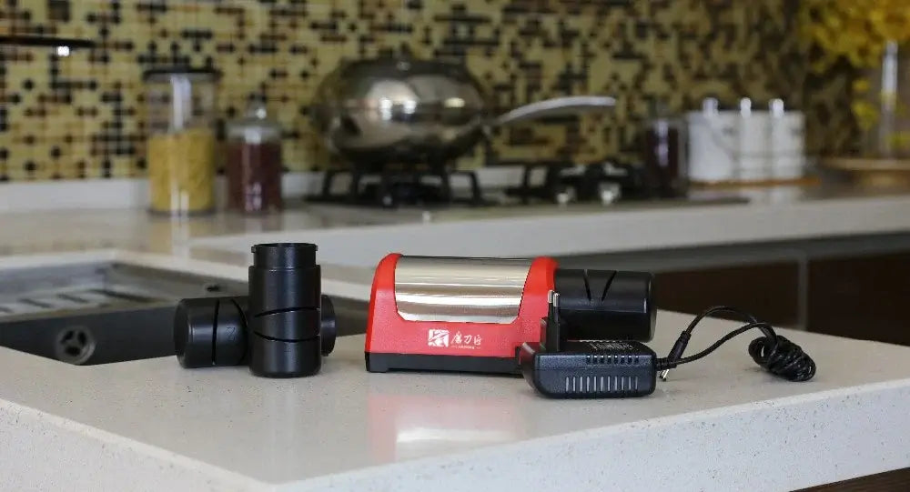 Electric knife sharpener on a kitchen countertop with modern decor, featuring a sleek red and silver design.