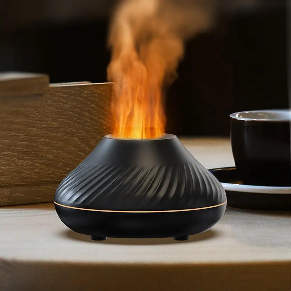 A black Aromatherapy Humidifier Nordic Design Humidifier, featuring a swirled pattern, emits an orange flame-like mist. Positioned on a table beside a stack of books and a black ceramic cup and saucer, it blends essential oils for relaxation with its Nordic aesthetic, creating a warm and cozy atmosphere.