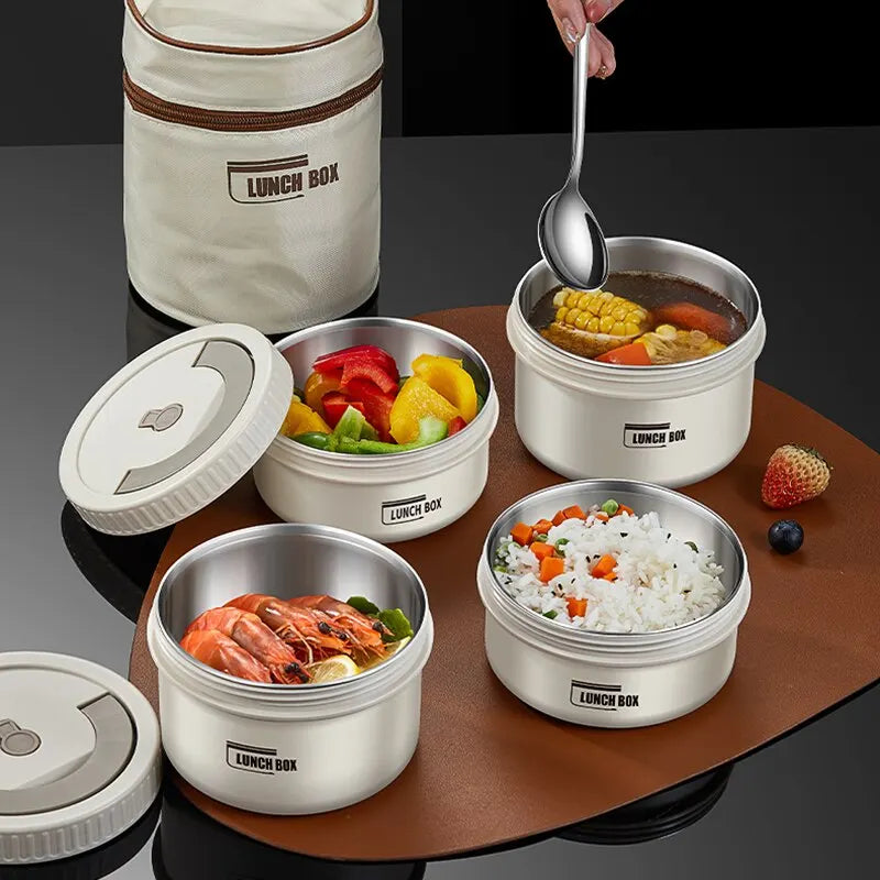 A set of Lunch Box containers featuring an assortment of foods: steamed shrimp, mixed vegetables, vegetable rice, and corn soup. A hand is poised with a spoon above the soup. In the background on a brown surface is a beige lunch bag offering superior thermal insulation.