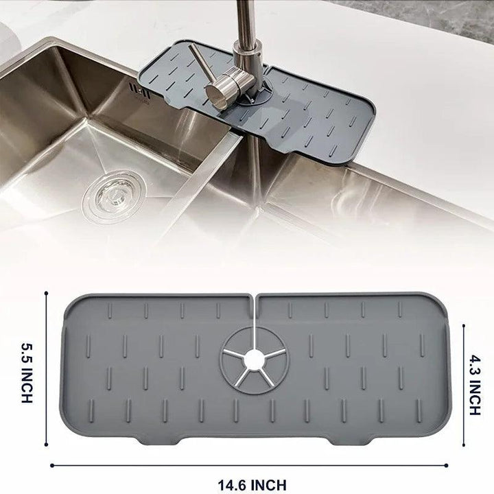 A Faucet Guard Kitchen Mat for Kitchen Sinks in gray, made from eco-friendly silicone and measuring 14.6 by 5.5 inches, is displayed on a kitchen sink. It features a central hole to accommodate the faucet base and raised lines to aid water drainage. An illustration underneath, showing its dimensions, adds clarity to the design of this specialty tool.