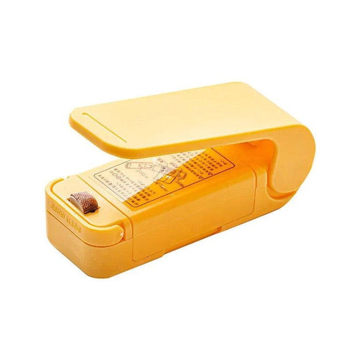 Introducing the "Heat Bag Sealer, Food Packaging Sealing Machine, Portable Snack Bag, Sealing Clip"—a vibrant yellow plastic handheld device with a clamshell design that doubles as a food-saver. This versatile tool includes instructional text and a top-surface button, making it ideal for securely sealing food storage bags.