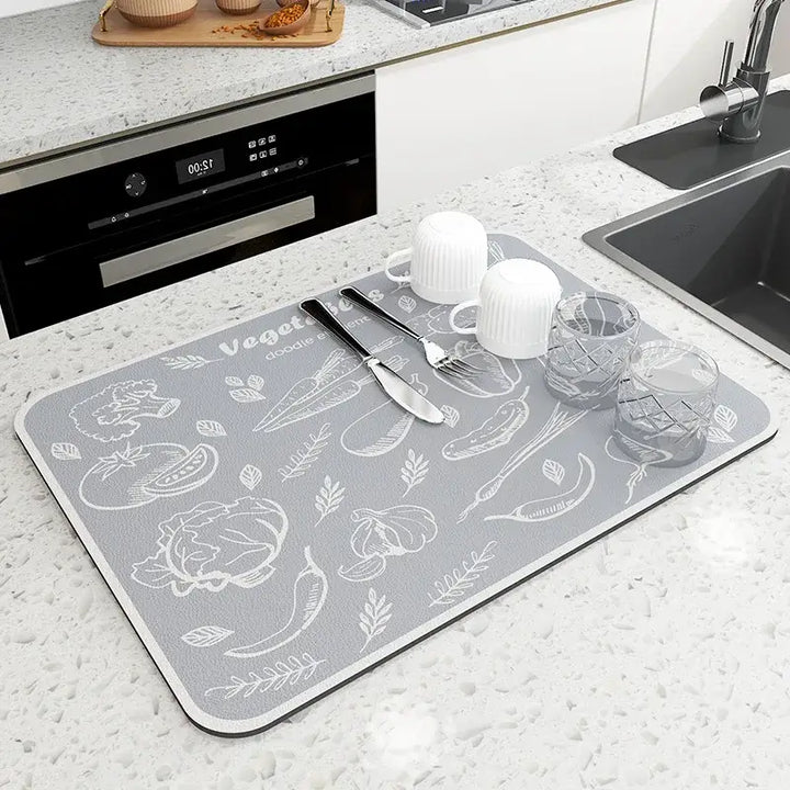 Kitchen mat with modern veggie design, diatom mud material, drying dishes and utensils on countertop. Eco-friendly and antiskid.