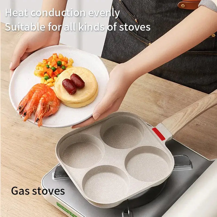 Non-stick egg frying pan with 4 holes on a stove, holding a plate of shrimp, sausage, and vegetables.