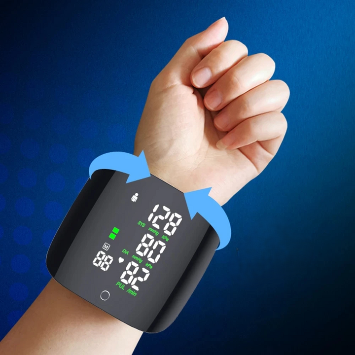 A hand wearing the Smart Wrist Sphygmomanometer with a Touchable Heart Rate Monitor displays readings in large white numbers against a dark background. Blue arrows indicate rotation direction. The gradient blue background enhances the screen's clarity, while the Voice Broadcast feature enhances usability for everyone.