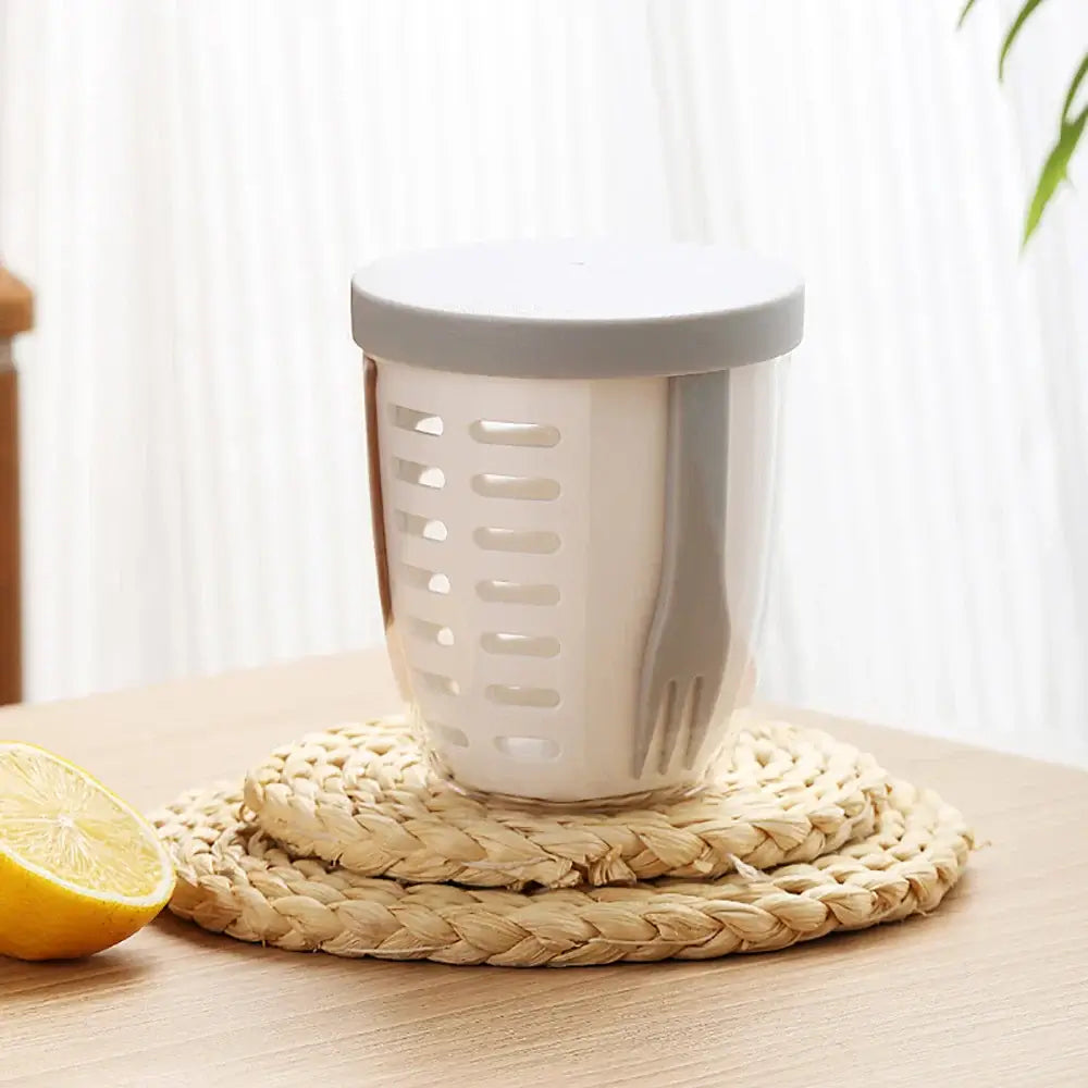 A lemon rests beside the Fruit Cup with Fork, a portable, eco-friendly, and leak-proof storage solution, ready to brighten up any meal.