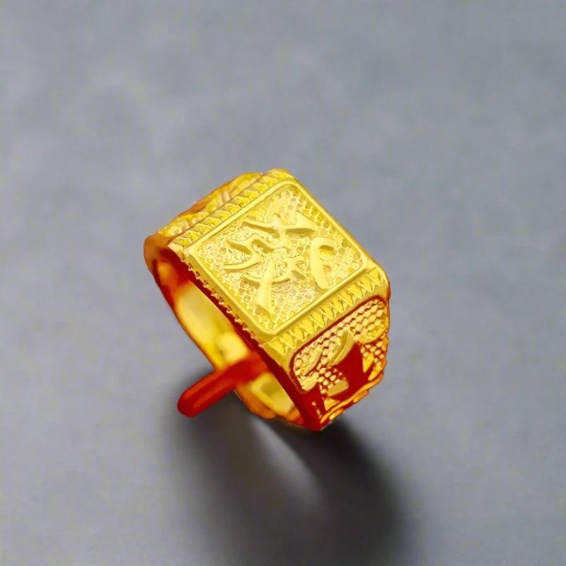 A rose gold ring for women featuring intricate engravings, including patterns and symbols, on its flat square top and band. The soft gray background enhances the ring's shine and details.