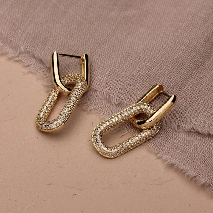 A pair of gold plated earrings featuring a geometric design and adorned with fashion CZ stones.