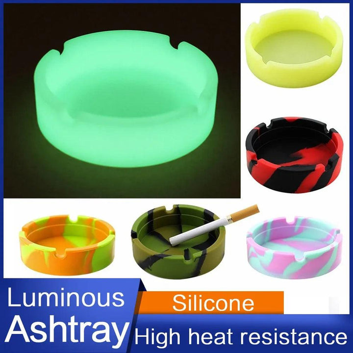 A collection of silicone gel ashtrays featuring a variety of colors and designs. One emits a green glow, accompanied by text that reads "Fluorescent Glow-in-the-Dark Ashtray, High Heat Resistant.