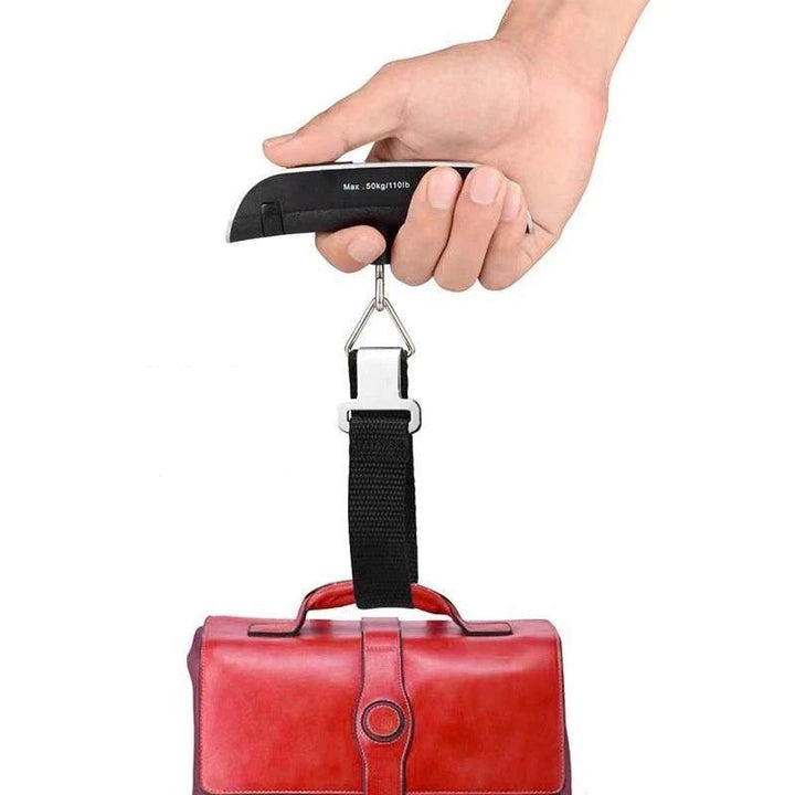 A hand holds a Digital Luggage Scale, Portable Suitcase Weighing Device with a hook, measuring the weight of a red leather bag. This compact travel scale displays a capacity of up to 50 kg or 110 lbs.