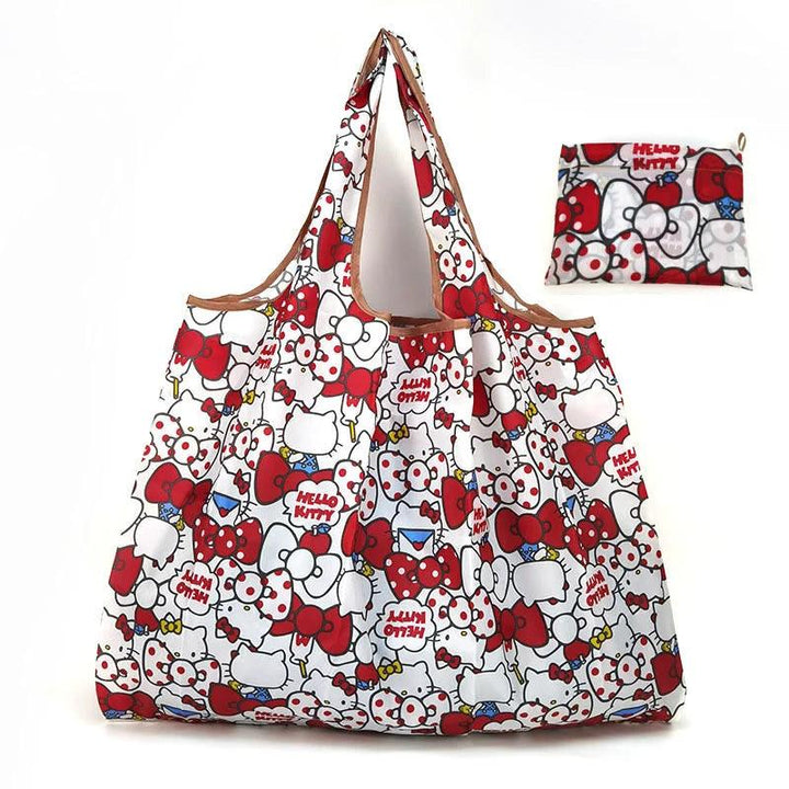 A large, flannel Tote Bag Foldable Shopping Bag flaunts a delightful Hello Kitty design with red bows and cheerful faces. Nearby, a smaller version of the same Tote Bag stays neatly folded, mirroring the same charming pattern.