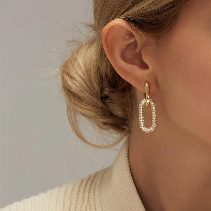 A close-up of a woman's ear adorned with elegant "Fashion CZ earrings" and showcasing the perfect blend of geometric design and subtle sophistication.