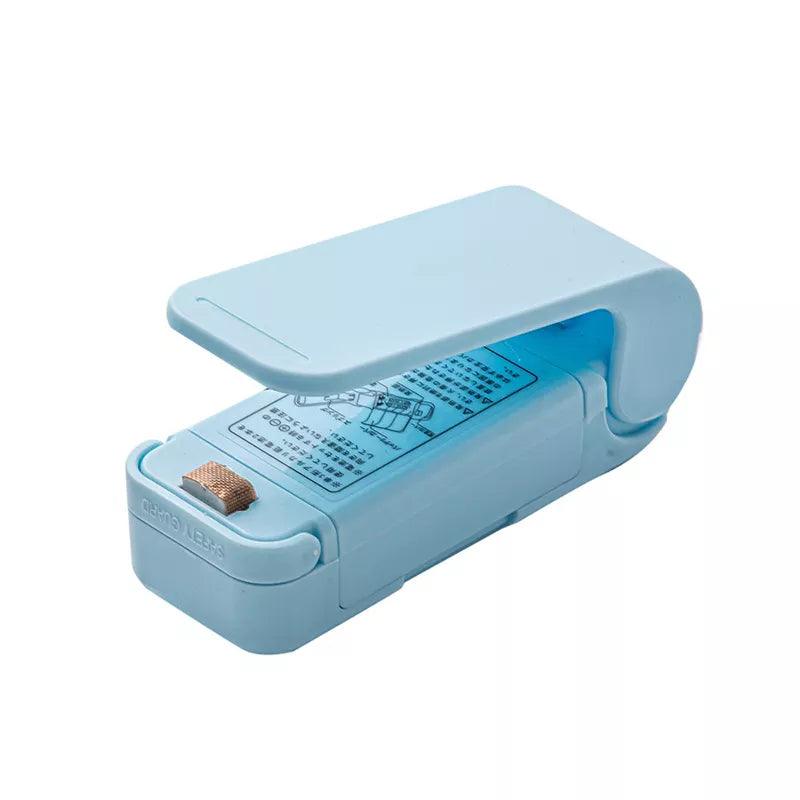 Introducing the Heat Bag Sealer, Food Packaging Sealing Machine, a portable tool perfect for sealing snack bags and food storage bags. This blue plastic handheld device comes with a cover and showcases a visible heating element along with labeled instructions, making it an ideal food-saving accessory.