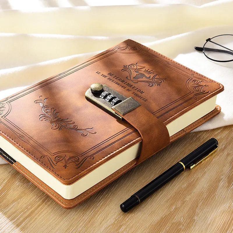 A Retro Password Notebook, featuring a brown leather cover with intricate designs and a combination lock, rests on a wooden surface. Accompanying it are a black pen with gold accents and a pair of black-rimmed glasses. A soft, light-colored fabric provides the backdrop.