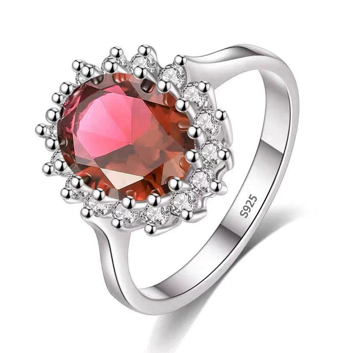 A luxurious and elegant Tibetan Created Ruby/Sapphire Ring, showcasing a large oval Tibetan Created Ruby surrounded by small clear stones in individual prongs. Crafted from sterling silver and engraved with "S925," this exquisite piece of gemstone jewelry stands out for its handcrafted design.