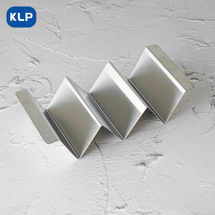 KLP 4-piece stainless steel taco holder with V-shaped design for holding tacos and hot dogs on a textured surface.