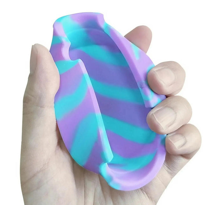 A hand holds a premium silicone gel ashtray featuring a vibrant purple and teal striped design, ideal for those who enjoy striking accessories.