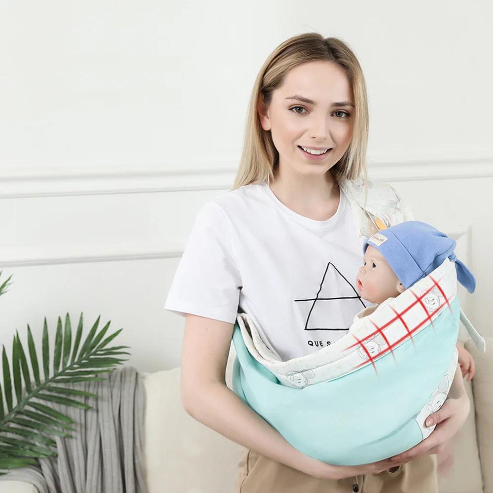 A woman wearing a white t-shirt gently holds her baby in the Adjustable Baby Carrier Wrap, Ring Sling Breastfeeding Convenience. The infant, wearing a blue hat, looks up inquisitively. A plant and a gray blanket serve as the backdrop.