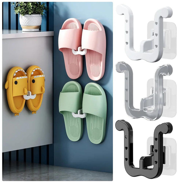 Three pairs of slippers in pink, green, and yellow are neatly hung on a wall-mounted shoe rack using "Slippers hanger hooks" in white, gray, and black. A potted plant adds charm to the nearby shelf, providing a stylish yet space-saving organizer solution with our "Organizers for small objects" for your home.