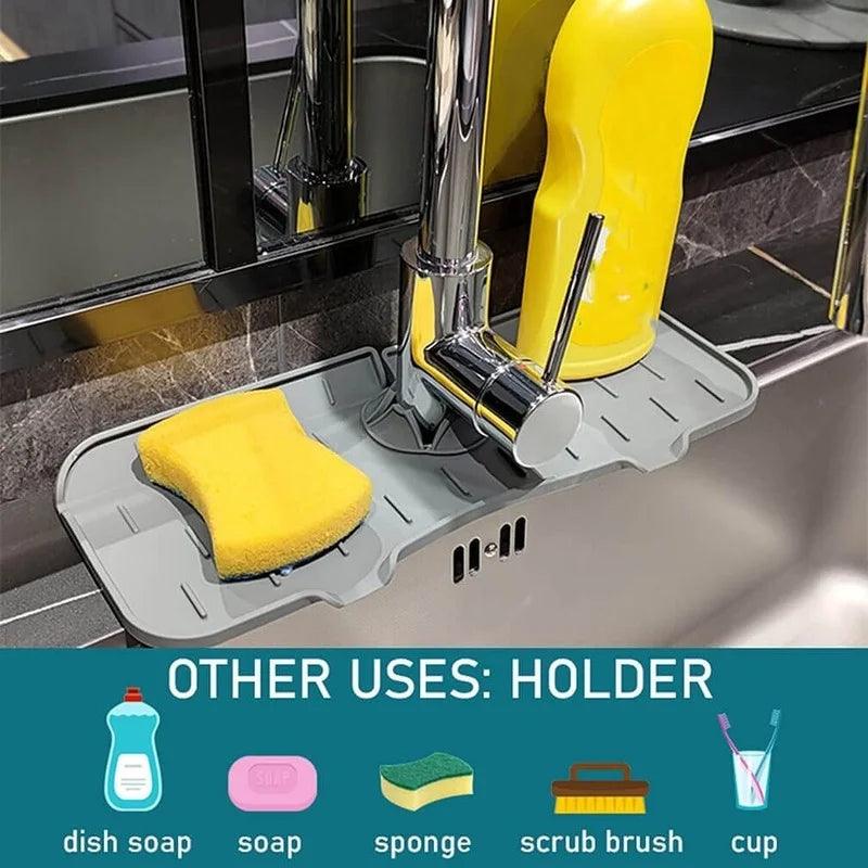 The Faucet Guard Kitchen Mat features a gray silicone holder attached to the faucet, displaying an eco-friendly yellow sponge, dish soap, and a scrub brush. It's perfect for organizing various cleaning items, as demonstrated by labeled icons below the image.