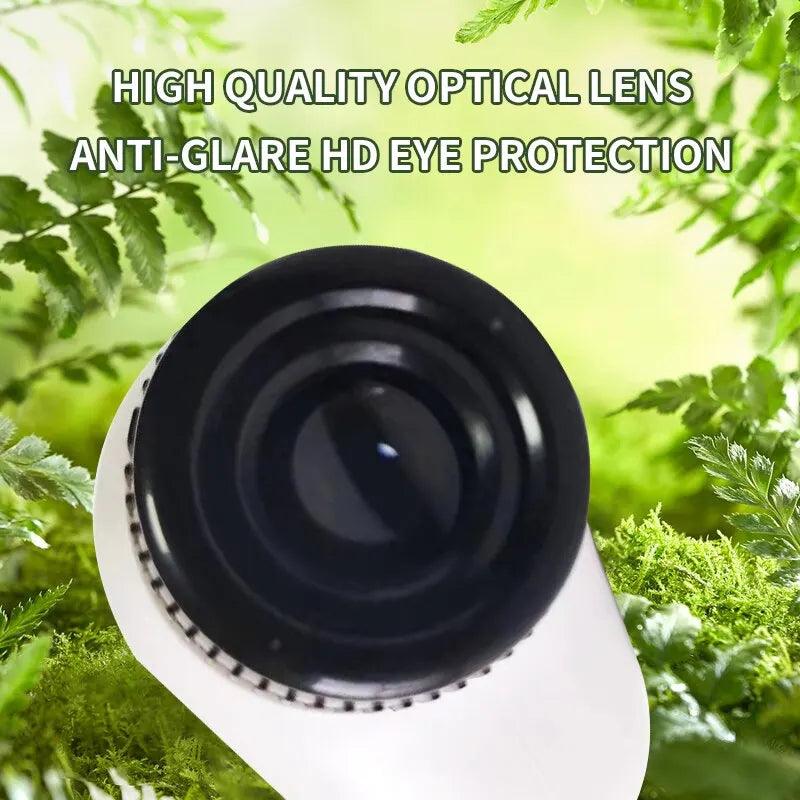 A premium optical lens, featured in the Microscope Portable Laboratory from the Microscope Kids Science Experiment Kit, is set against a green, leafy background. Above the lens, text states: "High Quality Optical Lens Anti-Glare HD Eye Protection." Discover magnification ranging from 60 to 120x with this innovative tool.