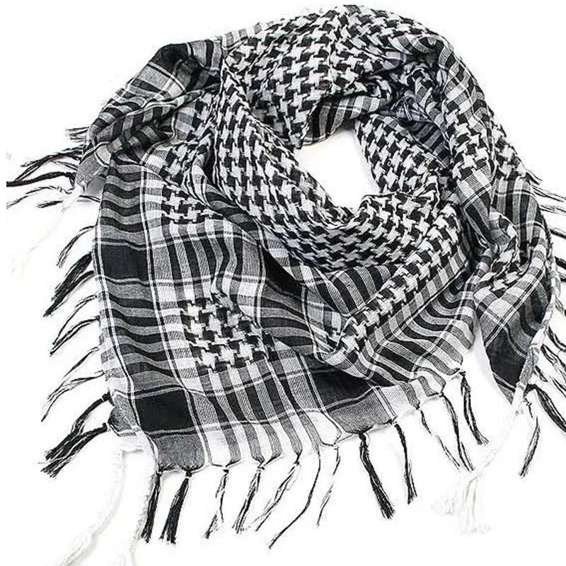 The "Arab Scarf Fashion Hijab Plaid Head Scarf" is a black and white checkered shemagh with tassels along the edges. Its pattern features an intricate mix of small squares and stripes, seamlessly blending traditional and modern designs, which makes it a versatile addition to any wardrobe.