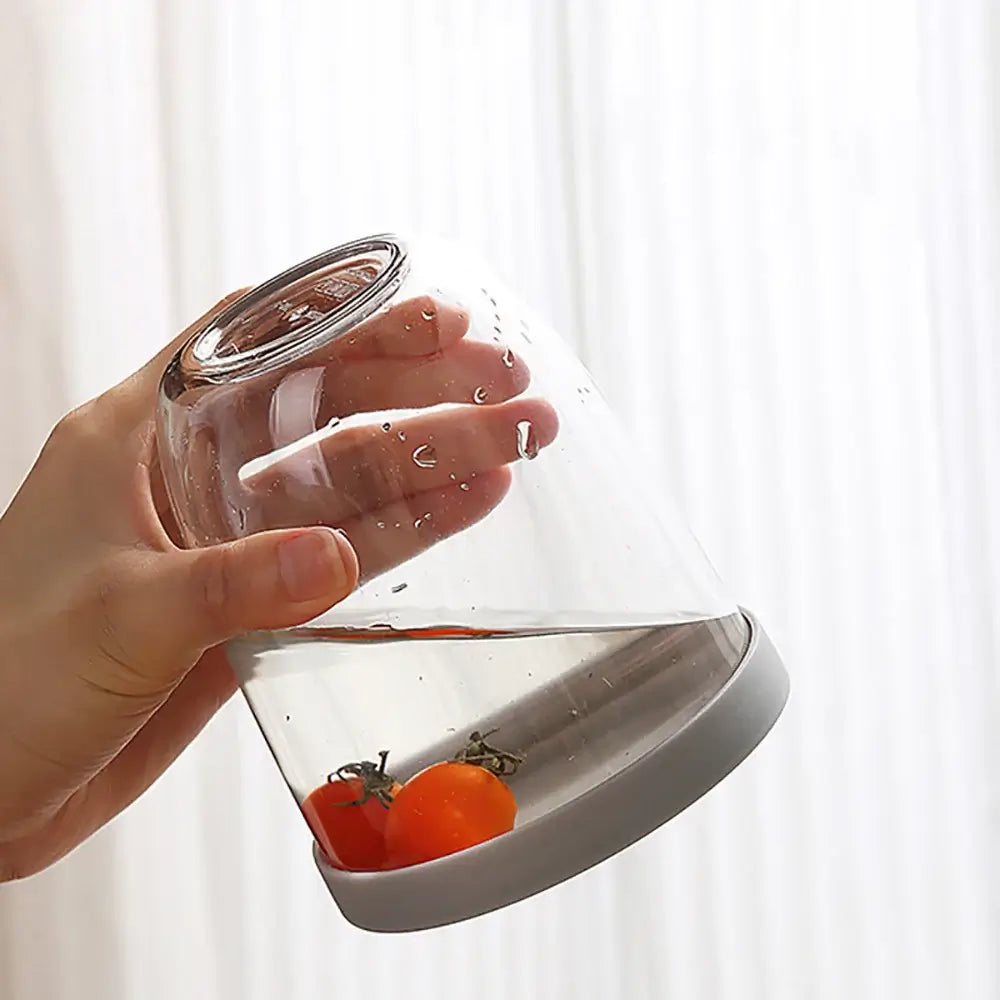 A hand holding the "Fruit Cup with Fork Portable Picnic Bottle," designed for eco-friendly and spill-free storage, elegantly displays its chic functionality with tomatoes securely inside.