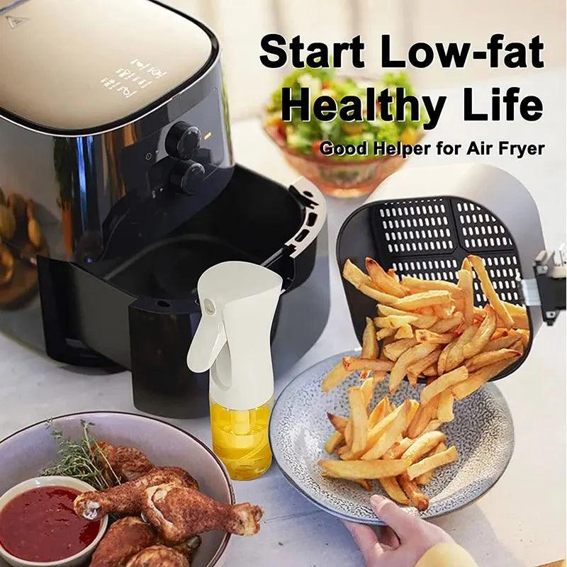 Using an air fryer, a person prepares fries and holds a basket brimming with crispy goodness. Nearby rests a bowl filled with fried chicken, complemented by the eco-friendly Oil Spray Bottle - Kitchen BBQ Cooking Olive Oil Dispenser - perfect for enhancing your cooking experience. The text reads "Start Low-fat Healthy Life: Good Helper for Air Fryer Cooking.