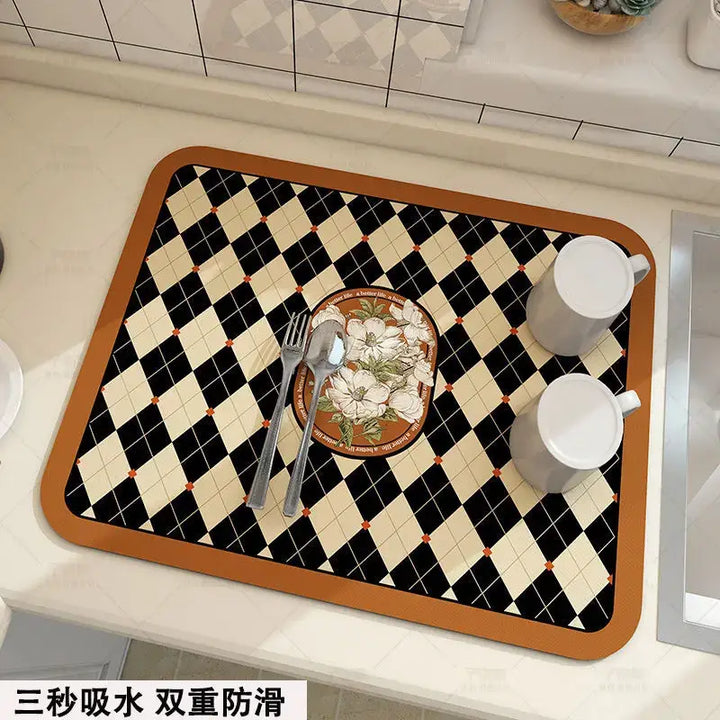 Kitchen mat with checkered pattern and floral centerpiece, two white mugs placed on top, on a countertop.