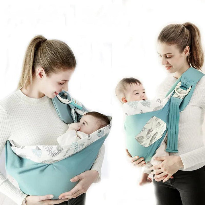 A woman with her hair in a ponytail is holding a baby wrapped in a turquoise Baby wrap, baby sling, baby carrier wrap. Featuring patterned lining, this cozy carrier is made of breathable cotton mesh fabric. She gazes lovingly at the baby, who looks up at her, as they both wear light-colored tops.