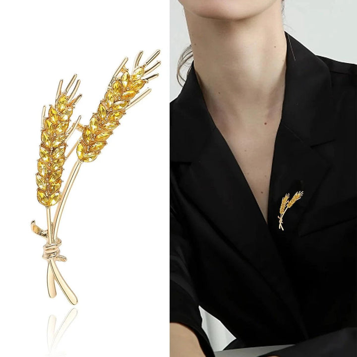 A chic Rhinestone lapel pin, designed from zinc alloy and shaped like two stalks of wheat, graces the lapel of a person in a black blazer. This unisex accessory features detailed craftsmanship and a polished finish.