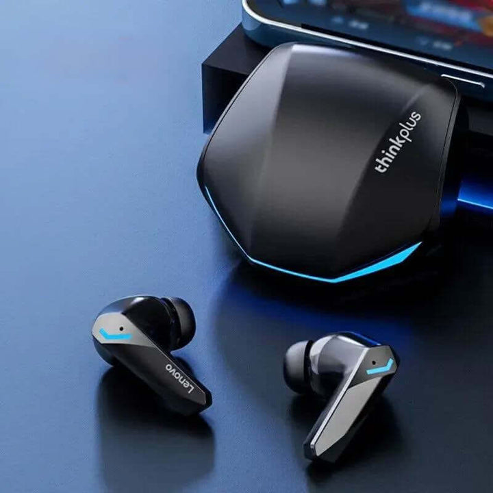 A pair of black Earphones Bluetooth gaming headset with blue accents are placed beside their hexagonal charging case, which also features blue highlights. Enhanced with Bluetooth 5.3 technology, these earphones provide seamless connectivity. A smartphone can be partially seen in the background.