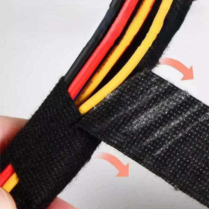 A close-up shows a hand wrapping a bundle of multicolored wires with the Heat Resistant Electrical Tape Insulation Fabric Cloth Tape. The black tape is partially unrolled, exposing the wires underneath, while two curved arrows illustrate the wrapping motion—ideal for securing automotive wiring harnesses.